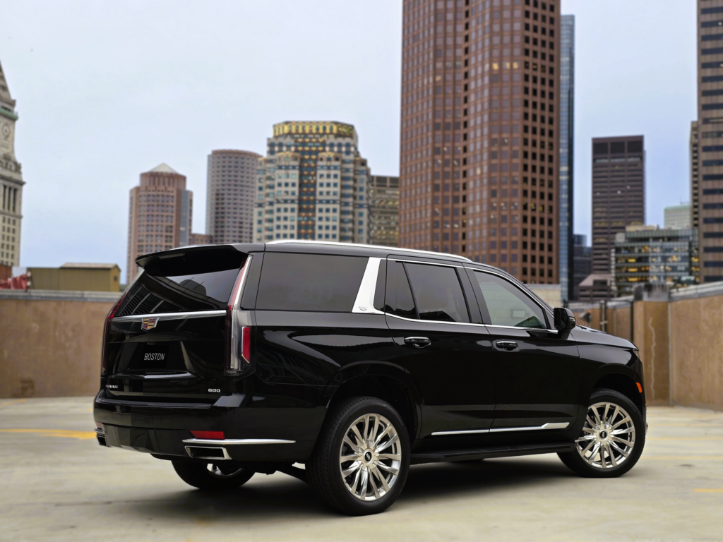 Rear three-quarter view of Cadillac Escalade with Boston city buildings