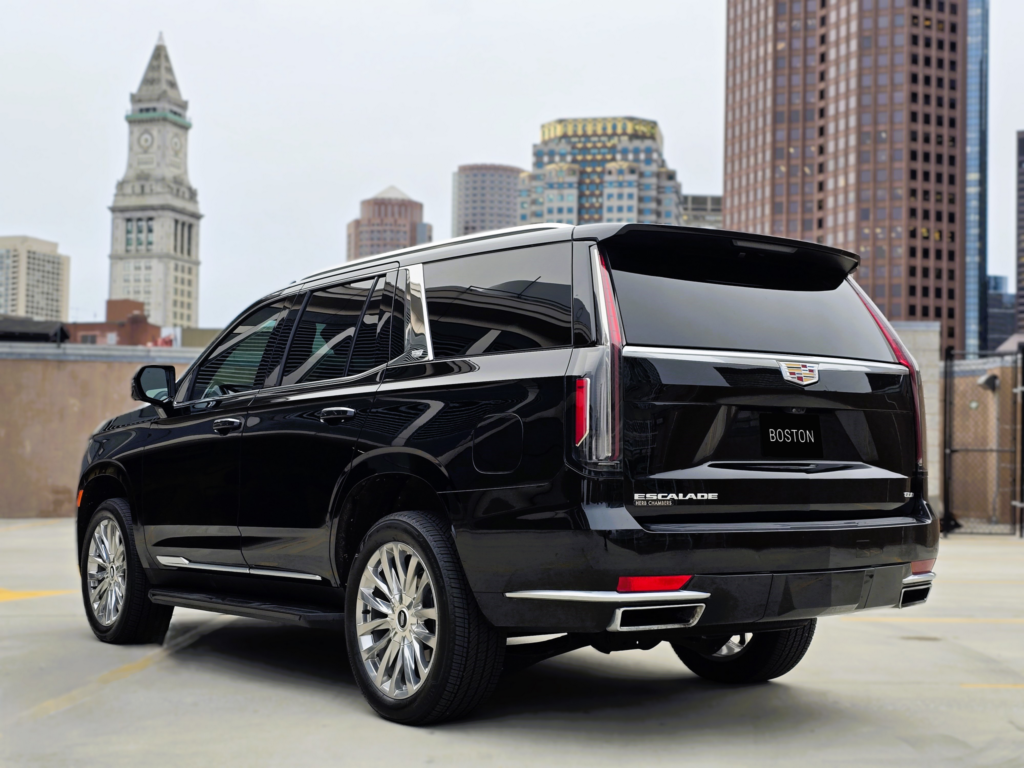 Rear three-quarter view of Cadillac Escalade with Boston city buildings