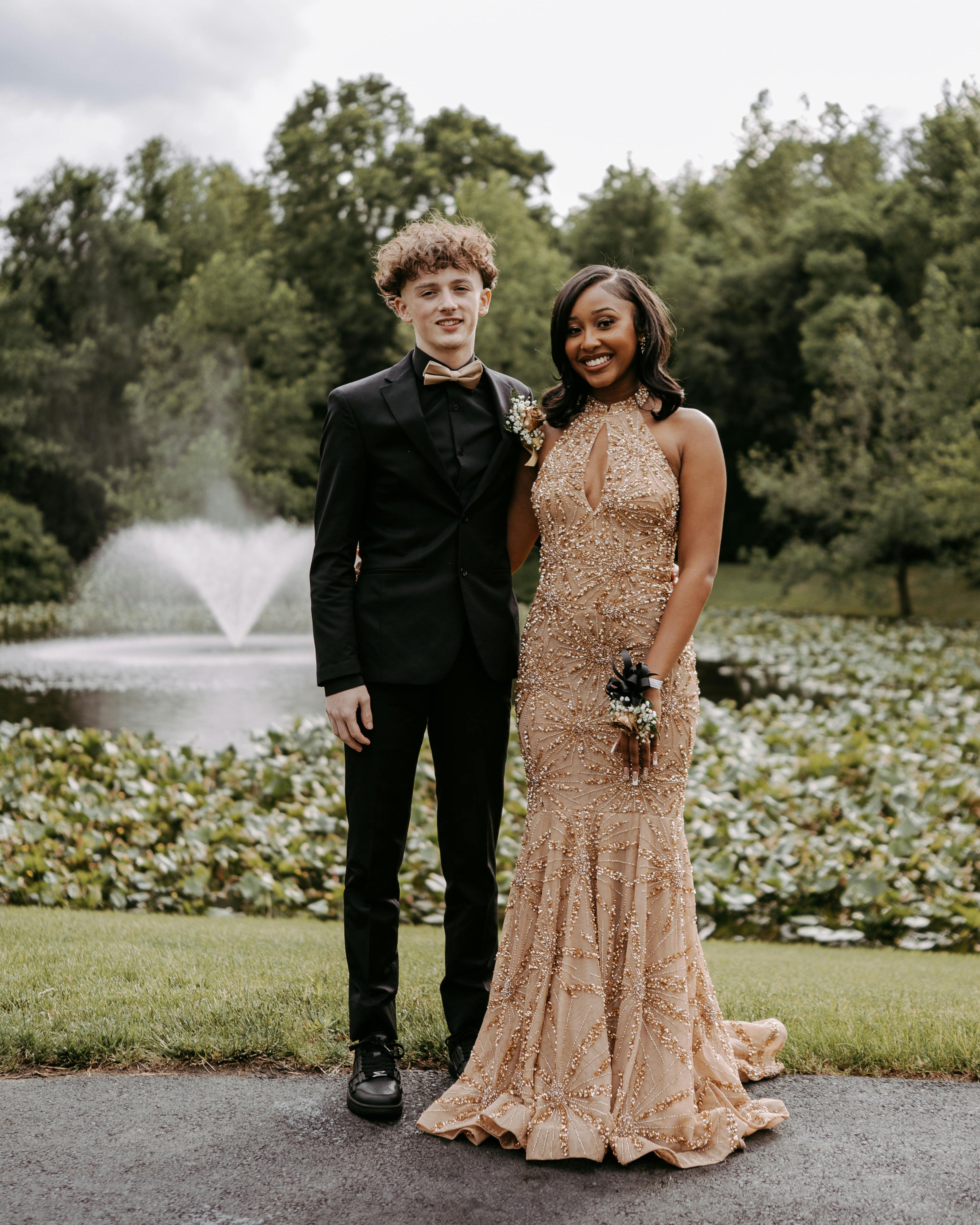 Couple dressed in formal attire posing together at prom