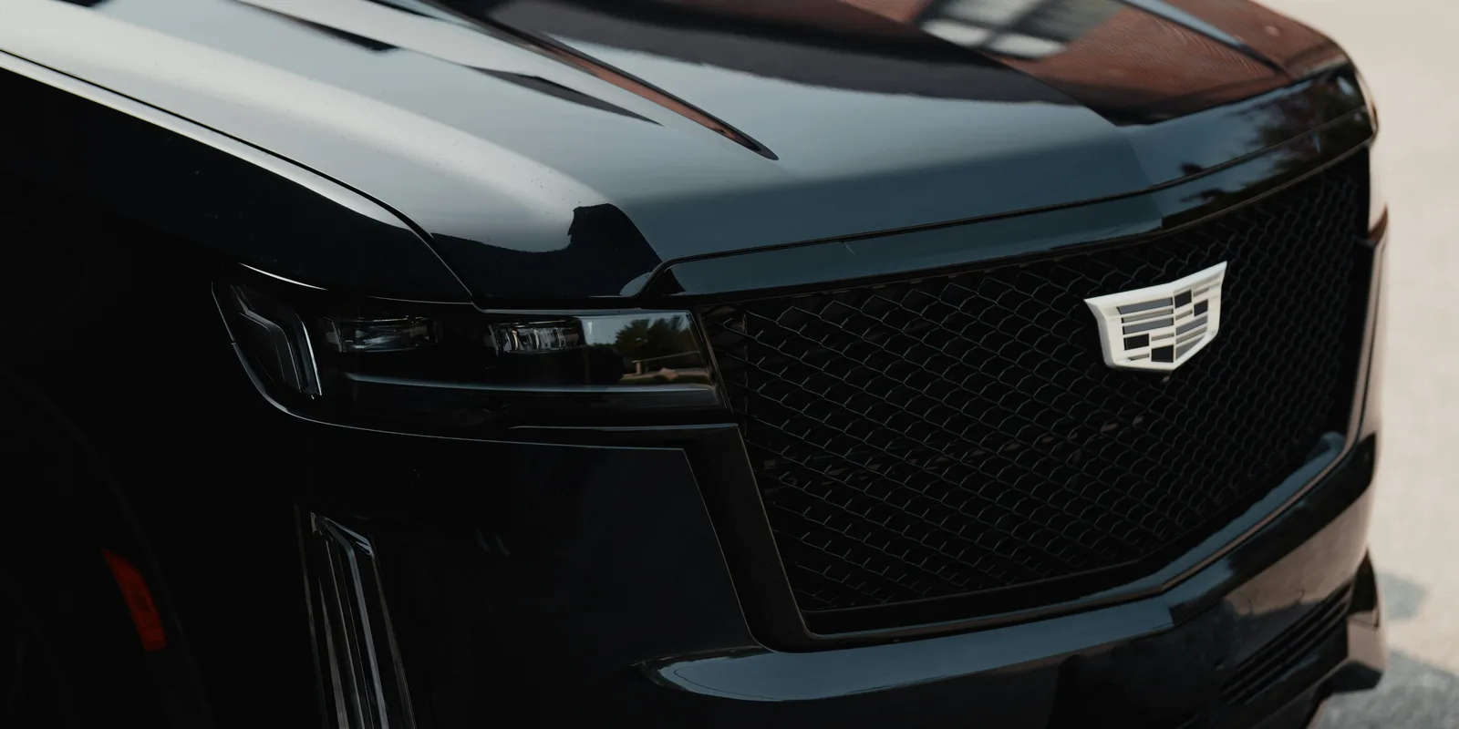 Cadillac Escalade front grille and badge, representing the Escalade ESV Sport Platinum available to rent in Boston