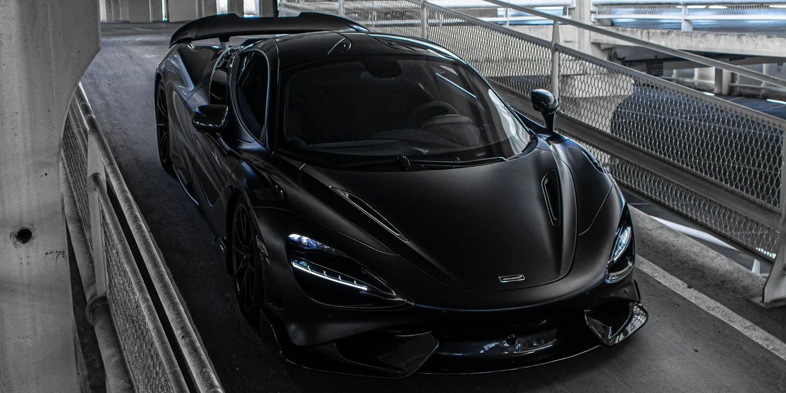 McLaren supercar in a parking garage, representing the McLaren 570S Spider available to rent in Boston